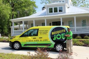 Technician standing next to Yellow and Black Mosquito Joe Service Van